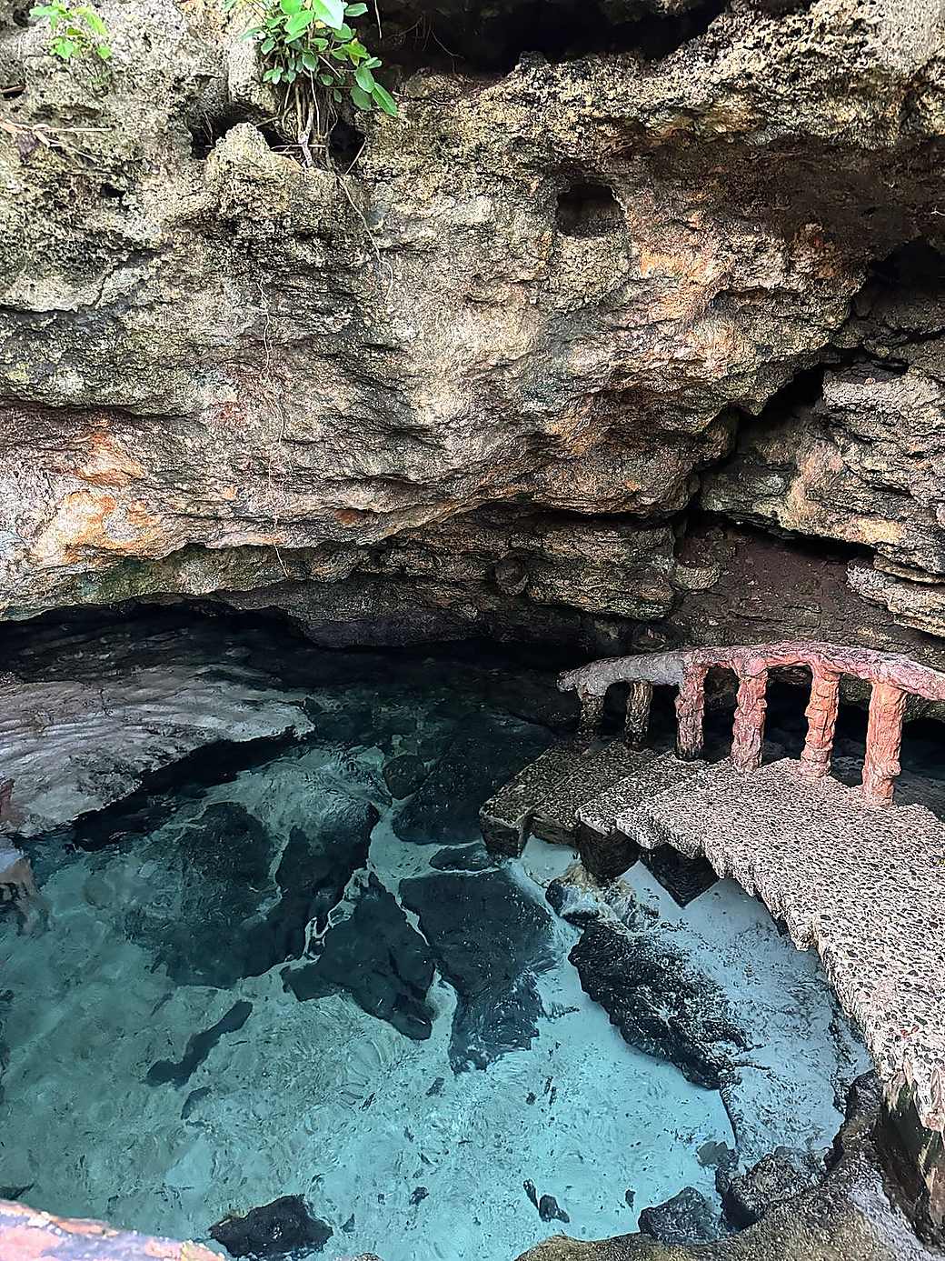 Two people swimming together in a tropical cave